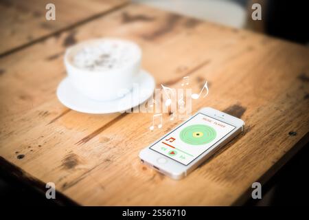 Musik Smartphone mit einer Tasse Kaffee auf Holztisch. Stockfoto