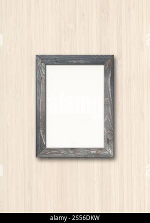 Alte graue rustikale Holzbilderahmen, die an einer Holzwand hängen. Leere Modellvorlage. Alter rustikaler HolzBilderrahmen, der an einer Holzwand hängt Stockfoto