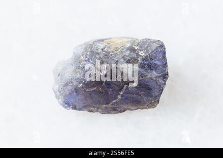 Nahaufnahme der Probe des natürlichen Minerals aus der geologischen Sammlung - Grober Cordierit (Iolit) Kristall auf weißem Marmorgrund aus Madagaskar Stockfoto