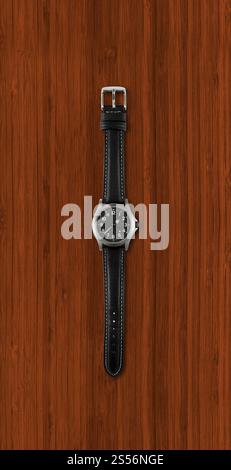 Schwarze Armbanduhr isoliert auf dunklem hölzernem Hintergrund. Armbanduhr isoliert auf dunklem hölzernem Hintergrund Stockfoto