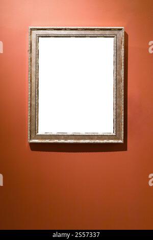 Breiter versilberter Bilderrahmen mit ausgeschnittem Canvas auf Rot Braune Wand Stockfoto
