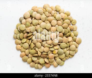 Draufsicht auf Stapel von rohen ganzen großen grünen Linsen Nahaufnahme der grauen Keramikplatte Stockfoto