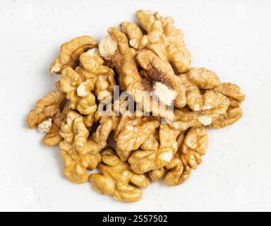 Draufsicht auf den Haufen geschälter Walnüsse aus nächster Nähe Graue Keramikplatte Stockfoto