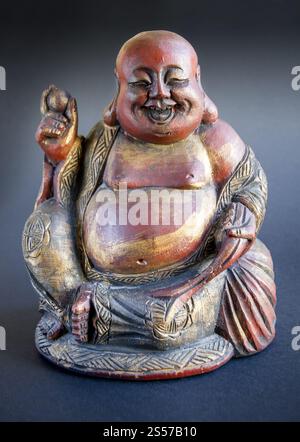 Traditionelle Holzstatue des chinesischen Buddha isoliert auf dunklem Hintergrund. Traditionelle Holzstatue des chinesischen Buddha Stockfoto