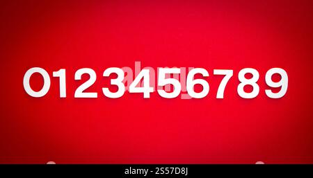 Mathematischer Hintergrund mit Zahlen von 1 bis 9 auf einer roten Tafel. Mathematikhintergrund mit festen Zahlen. Isoliert auf Rot Stockfoto