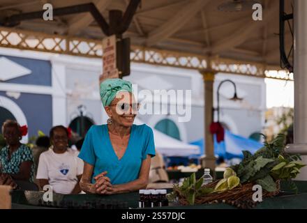 St. Thomas, USA – 24. März 2018: Die Marktfrau verkauft Gemüse am Marktplatz in Charlotte Amalie. Stockfoto