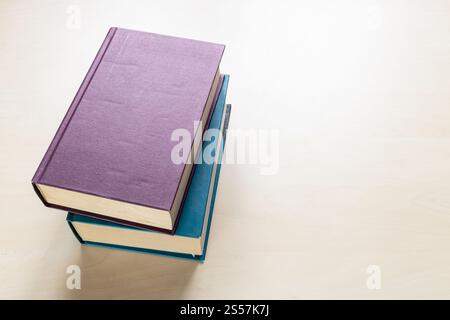 Draufsicht auf zwei dicke Bücher auf hellbraunem Holzbrett Stockfoto