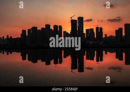 Silhouette der Skyline der Stadt Chongqing mit Reflexion, China während des Sonnenuntergangs. Stockfoto