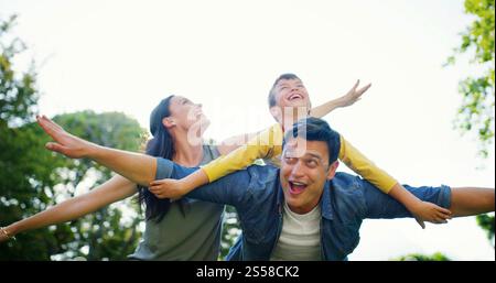 Familien-, Huckepack- und Outdoor-Fliegen für Spaß, Fantasy-Abenteuer und Ferienpark zum Binden. Glücklicher Sohn, Eltern und Natur für Unterstützung mit dem Flugzeug Stockfoto