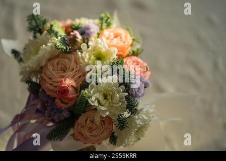 Wunderschöner Blumenstrauß mit weichen Rosen, weißen Chrysanthemen, kleinen lila Blumen und frischen Kiefernzweigen schafft ein schönes Arrangement, das perfekt für verschiedene Anlässe ist Stockfoto
