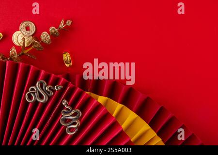 Chinesisches asien Neujahr goldener roter Hintergrund. Neue Grußkarte für das Jahr der Schlange 2025 mit Sternzeichen. Roter flacher Hintergrund mit Weihnachtsfans, Wunschumschläge, sn Stockfoto