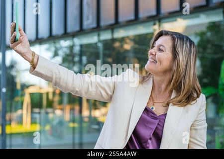 Lächelnde Frau, die draußen ein Selfie macht Stockfoto