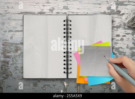 Haftnotizen mit offenen leere Notizbuch auf Schreibtisch Top Textur Stockfoto
