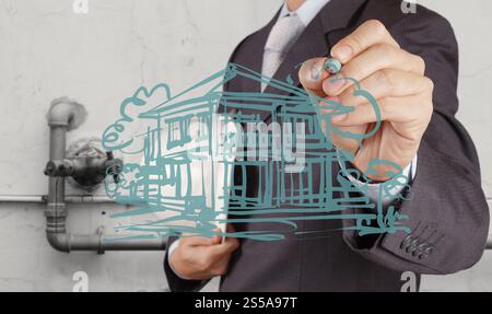Geschäftsmann Handzeichnung Hausmodell auf modernen Computer als Entwicklungskonzept Stockfoto