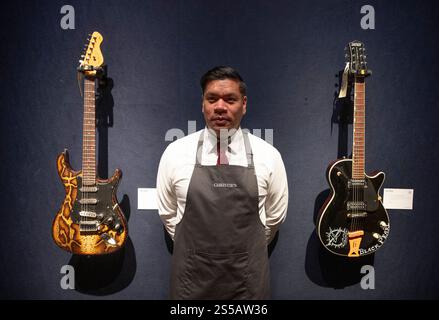 Christie's, London, Großbritannien. Januar 2025. Die Londoner Auktion des mehrfach-Grammy-Preisträgers Jeff Beck (1944–2023), der zweimal in die Rock & Roll Hall of Fame aufgenommen wurde, findet am 22. Januar 2025 statt. Dieser einzigartige Verkauf von über 130 Gitarren, Amps und „Werkzeugen des Handels“, den Jeff während seiner fast sechs Jahrzehnte langen Karriere spielte, von The Yardbirds im Jahr 1965 bis zu seiner letzten Tour im Jahr 2022. Bild: Christies Kunsthandler mit zwei Gitarren aus der umfangreichen Sammlung. Quelle: Malcolm Park/Alamy Live News Stockfoto