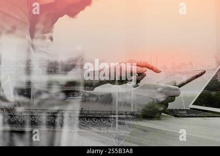 Doppelbelichtung von Website-Designer Brillen funktionierende Computer Laptop, digital-Tablette auf Holztisch, London Architektur Gebäude halten Stockfoto