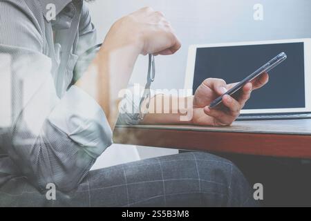 Erfolg Geschäftsmann Hand mit Brillen, Smartphone, Digital tablet Docking-smart-Tastatur auf Holz Schreibtisch Stockfoto