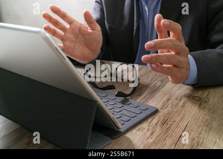 Erfolg Geschäftsmann Hand mit Brille, Digital Tablet Docking Smart Tastatur auf Holzschreibtisch Stockfoto