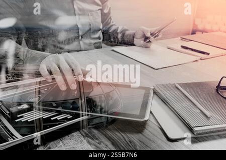 Doppelbelichtung Website Designer Holding Smartphone und funktionierende Computer digital-Tablette auf Holztisch, London Architektur buldings Stockfoto