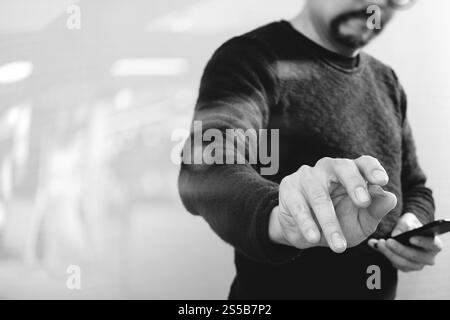 Geschäftsmann Hand mit Stift eine imaginäre Taste halten, Smartphone, grafische virtuellen digitalen Bildschirmsymbole, Diagramm, Diagramm, schwarz weiß Stockfoto