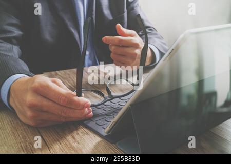 Erfolg Geschäftsmann Hand mit Brillen, digital-Tablette Docking-smart-Tastatur auf Holz Schreibtisch, Filter-Effekt Stockfoto