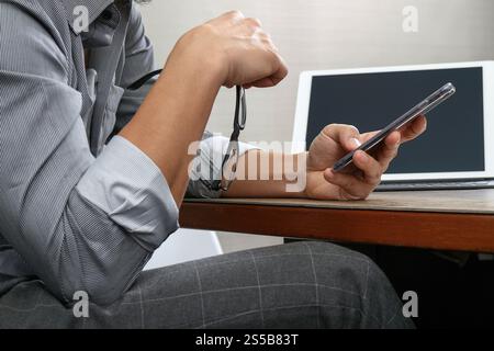 Erfolg Geschäftsmann Hand mit Brillen, Smartphone, Digital tablet Docking-smart-Tastatur auf Holz Schreibtisch Stockfoto