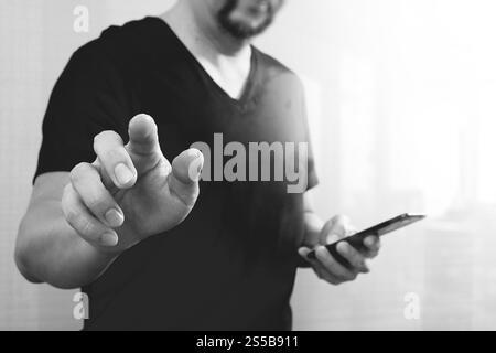 Geschäftsmann Hand einen imaginären Taste halten, Smartphone, grafische virtuellen digitalen Bildschirmsymbole, Diagramm, Diagramm, schwarz weiß Stockfoto