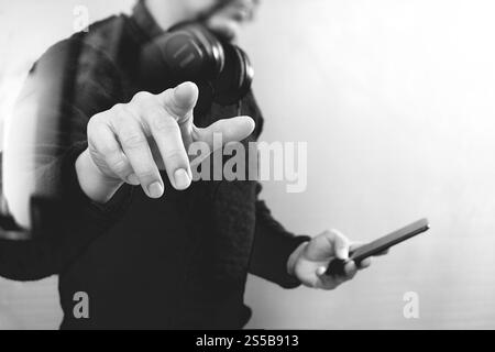 Geschäftsmann Hand einen imaginären Taste halten, Smartphone, grafische virtuellen digitalen Bildschirmsymbole, Diagramm, Diagramm, schwarz weiß Stockfoto