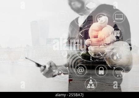 Doppelte Belichtung der Designer-Hand durch Drücken einer imaginären Taste, Halten des Smartphones, digitaler Bildschirm grafische virtuelle Symbole, Kanal, Diagramm, London Stockfoto