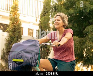 Nahaufnahme einer lächelnden Frau, die an einem Gebäude vorbeiradelt, Florida, USA Stockfoto