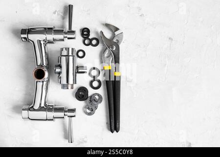 Sanitär Hintergrund - Draufsicht auf Schlüssel, Dichtungen, zerlegtes Dusche Wasserhahn Ventil, Umleiter auf Betonplatte mit Copyspace Stockfoto
