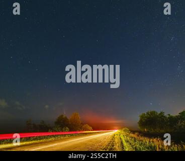 Komet Neowise C2020 F3, wie er im Sommerhimmel über einer Wiese in der Nähe der Landstraße, Region Lviv, Ukraine fliegt. Stockfoto