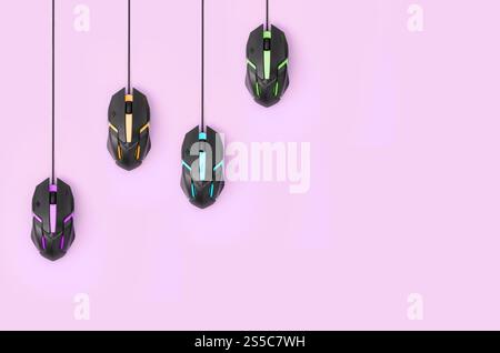 Mehrere Computermäuse hängen auf einem pastellrosa Hintergrund. Das Konzept kooperativer Computervideospiele, die Verwendung von Auto-Clicker und Pay-per-Click Stockfoto