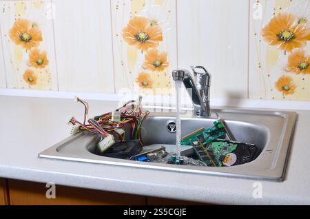 PC-Reinigung metaphorisches Konzept. Hardware in Küchenspüle unter dem Wasserfluss. Hardware in Küchenspüle unter dem Wasserstrom-Computer Stockfoto