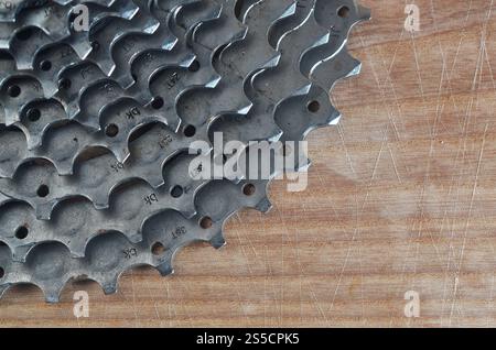 Hintergrundbild einer hinteren Kassette eines Mountainbikes, das auf einem Holztisch in einem Fahrradgeschäft liegt. Eine der Hauptkomponenten für das Einschalten von Geschwindigkeiten Stockfoto