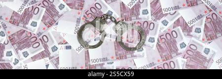 Handschellen auf 500 Euro Hintergrund. Finanzkriminalität, schmutziges Geld und Korruption - 500 Geldscheine und schmutzige Stahlhandschellen Stockfoto