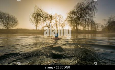 Stimmungsvolle Aufnahme einer einsamen weiblichen Wildnis, die an einem nebeligen Wintermorgen bei Sonnenaufgang in die Ferne schwimmt. York Stockfoto