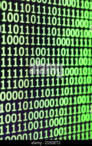 Makroaufnahme von Binärcode auf dem Monitor eines Bürocomputers. Das Konzept der Programmierer funktioniert. Der Fluss digitaler Informationszeichenfolgen Stockfoto