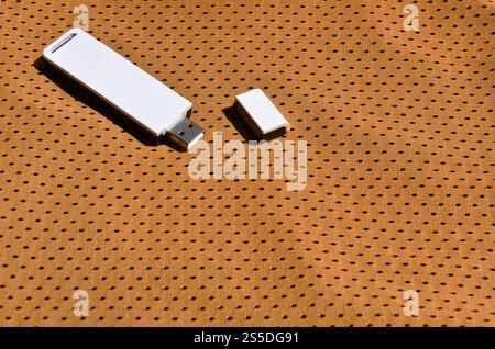 Eine moderne tragbare USB-WLAN-Adapter befindet sich auf der orangefarbenen Sportswear aus Polyester nylon Fibre platziert Stockfoto