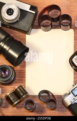 Vintage Retro-Kamera und altes Fotozubehör auf hölzernem Untergrund als Hintergrund mit Rohbildern, um Ihre Bilder oder Texte zu platzieren. Stillleben Stockfoto