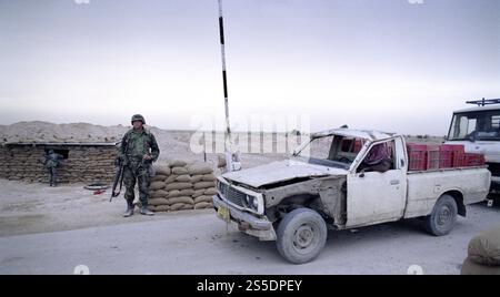 Erster Golfkrieg: 21. März 1991 ein irakischer Pickup-Truck wartet darauf, den Checkpoint Charlie zu passieren, der Grenze der Besetzung durch die US-Armee entlang des Highway 8, 8 km südlich von Nasiriyah im südlichen Irak. Stockfoto