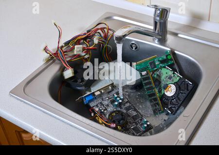 PC-Reinigung metaphorisches Konzept. Hardware in Küchenspüle unter dem Wasserfluss. Hardware in Küchenspüle unter dem Wasserstrom-Computer Stockfoto