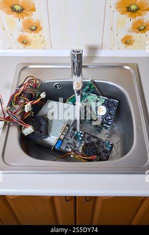 PC-Reinigung metaphorisches Konzept. Hardware in Küchenspüle unter dem Wasserfluss. Hardware in Küchenspüle unter dem Wasserstrom-Computer Stockfoto