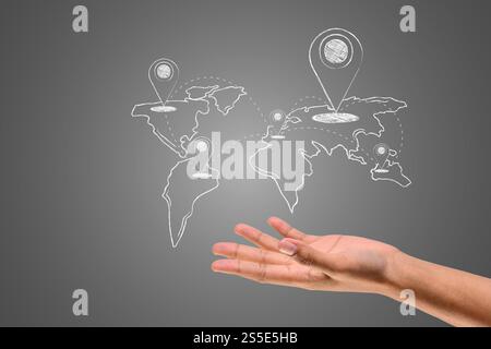 Die Koordinaten und die Weltkarte sind in weißer Kreide auf der Hand geschrieben, zeichnen Konzept. Stockfoto