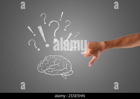 Das Gehirn mit vielen Fragen in weißer Kreide gemalt und der Daumen nach unten zeigt, zeichnen Konzept. Stockfoto