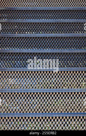 Die Strukturschritte rostiger Metallgitter in den Abschnitten der Metallbänder. Rostiges Metallgitter Stockfoto