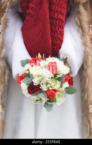 Winterstrauß in den Händen der Braut an einem verschneiten Tag Stockfoto