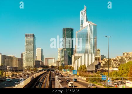 Städtische Skyline mit modernen Wolkenkratzern in La Defense und einer verkehrsreichen Autobahn unter klarem blauem Himmel, Paris, Frankreich Stockfoto