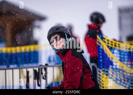 Ein junger Mann läuft auf einen Skilift in einem Skigebiet in Deutschland zu Stockfoto