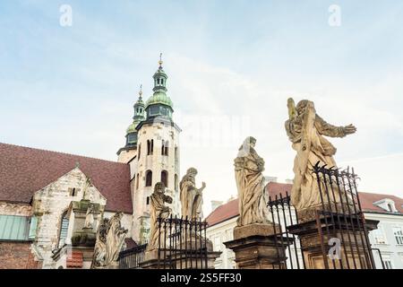 Barocke Skulpturen stehen vor einer historischen Andreakirche mit einem Glockenturm unter klarem Himmel in Krakau, Polen Stockfoto